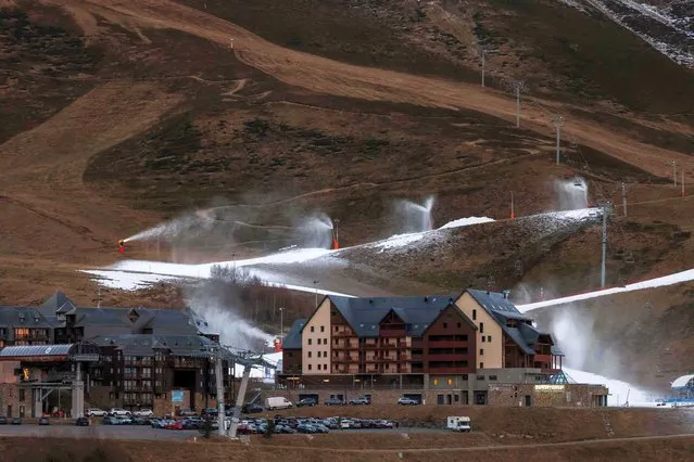 This photograph shows a general view of snow cannons operating due to lack of snow at the Peyragudesski resort, southwestern France on January 5, 2023. (Photo by Charly Triballeau/AFP Photo)