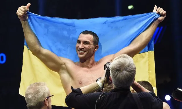 Ukrainian WBA, WBO, IBO and IBF heavyweight boxing world champion Vladimir Klitschko celebrates with a Ukrainian flag after he knocked down challenger Bulgarian heavyweight boxer Kubrat Pulev (not pictured) during their title fight in Hamburg, November 15, 2014. (Photo by Fabian Bimmer/Reuters)