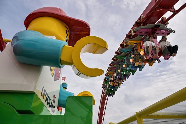 People ride a roller coaster at the new Legoland resort in Shanghai on Friday, June 20, 2025. (Photo by Hector Retamal/AFP Photo)
