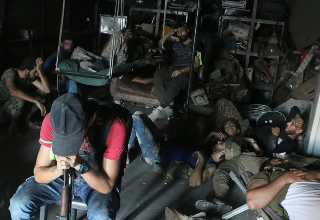 Free Syrian Army fighters rest inside a mechanic shop in Ramousah area southwest of Aleppo, Syria August 2, 2016. Picture taken August 2, 2016. (Photo by Ammar Abdullah/Reuters)