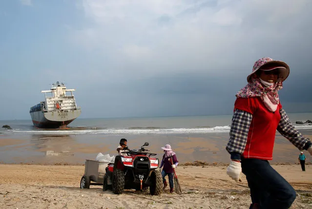 Cleaners walk in front of a Gang Tai Tai Zhou, a vessel that ran aground off the coast of Kinmen after typhoon Meranti drifted it from the Chinese city of Xiamen to Taiwan-controlled Kinmen, Taiwan September 30, 2016. (Photo by Tyrone Siu/Reuters)