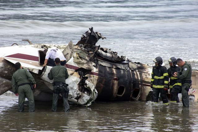 Rescue teams work after a private plane exploded and crashed into the Cruzeiro beach while attempting to take off from the Ubatuba airport, in Ubatuba, Sao Paulo state, Brazil, on January 9, 2025. According to Ubatuba City Hall, one person is dead and four other were injured. (Photo by Wendell Marques/AFP Photo)