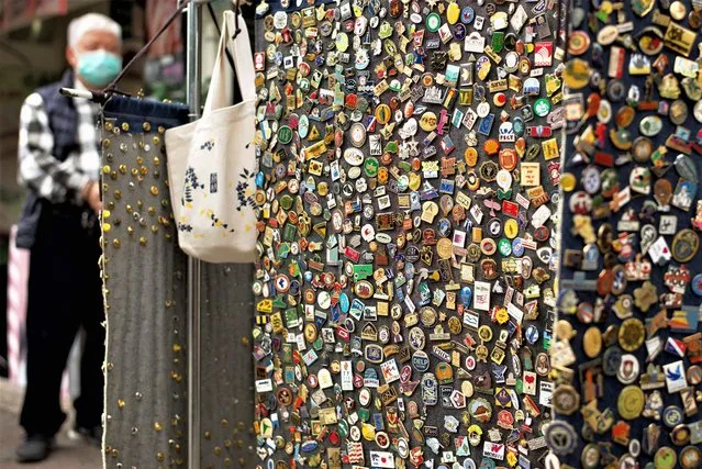 A vendor stands next to his pins on a street in Taipei on February 23, 2023. (Photo by Sam Yeh/AFP Photo)