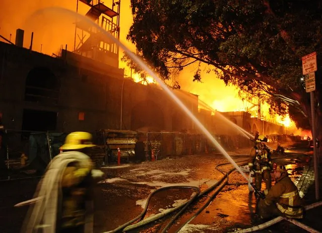 Los Angeles city firefighters battle a massive fire at a seven-story downtown apartment complex under construction in Los Angeles, California December  8, 2014. Over 250 firefighters battle the early morning blaze which shutdown two major freeways the Los Angeles Fire Department and California Highway Patrol said. (Photo by Gene Blevins/Reuters)