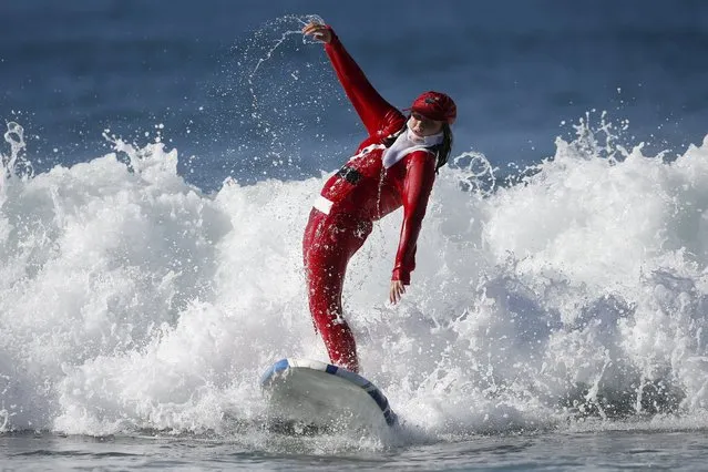 A competitor surfs dressed as Santa Claus during the ZJ Boarding House Haunted Heats Halloween Surf Contest in Santa Monica, California, United States, October 31, 2015. (Photo by Lucy Nicholson/Reuters)