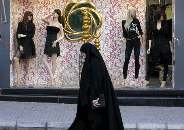 A Shi'ite Muslim woman walks past mannequins displaying black clothing in Nabatieh, southern Lebanon October 17, 2015. (Photo by Ali Hashisho/Reuters)