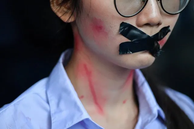 A student, who claims she was sexually abused by a teacher, has her mouth covered with tape as pro-democracy protesters demanding the resignation of Thailand's Prime Minister Prayut Chan-o-cha and reforms on the monarchy gather during a rally in Bangkok, Thailand on November 21, 2020. (Photo by Chalinee Thirasupa/Reuters)