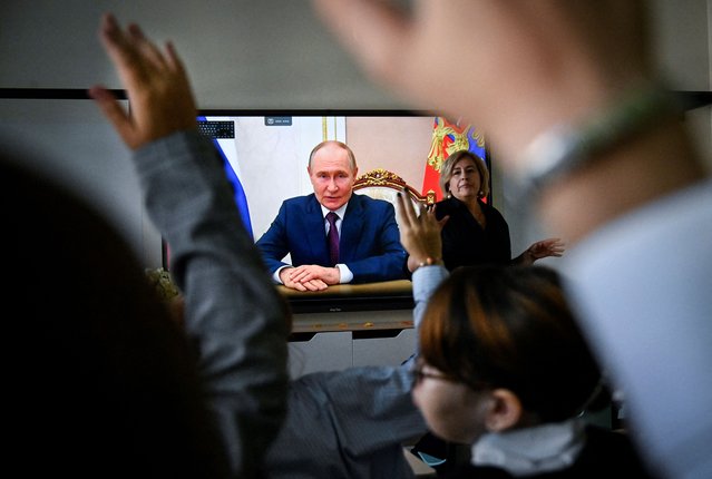 Pupils of a secondary school listen to Russia's President Vladimir Putin's address at the first day of the new school year in Moscow on September 1, 2025. (Photo by Alexander Nemenov/AFP Photo)