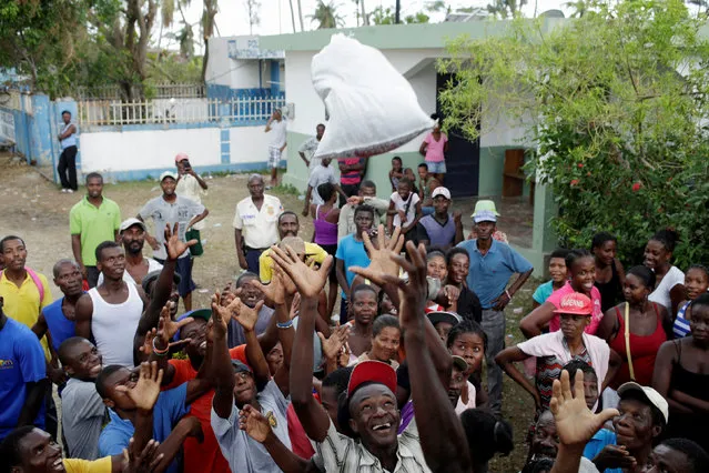 Residents try to grab a sack filled with food at the end of a food distribution after Hurricane Matthew in Saint Jean du Sud, Haiti, October 16, 2016. (Photo by Andres Martinez Casares/Reuters)