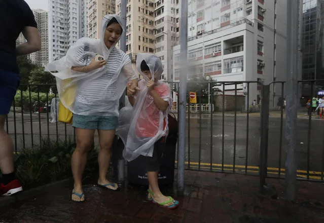 People brave the wind on the waterfront as Typhoon Haima approaches in Hong Kong, Friday, October 21, 2016. Typhoon Haima churned toward southern China on Friday after smashing into the northern Philippines with ferocious wind and rain, triggering flooding, landslides and power outages and killing seven people. (Photo by Kin Cheung/AP Photo)