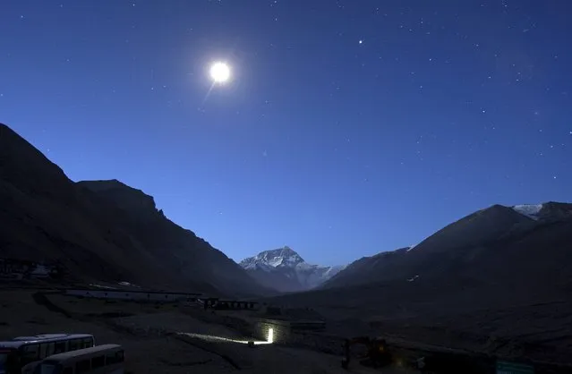 The first light of dawn illuminates Mount Everest as the moon shines above and a toilet block is seen in the foreground in the Tibet Autonomous Region, China, April 29, 2008. (Photo by David Gray/Reuters)