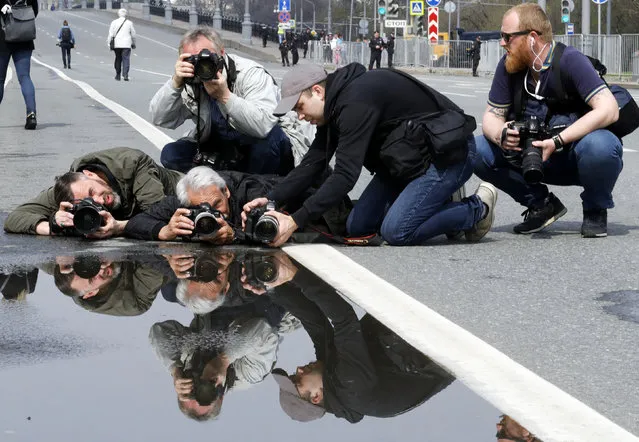 Photographers take pictures during a May Day rally held by supporters of left-wing political parties and movements in central Moscow, Russia May 1, 2018. (Photo by Tatyana Makeyeva/Reuters)