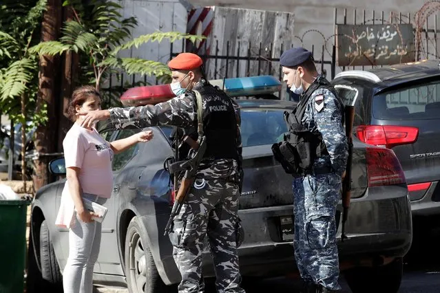 A relative of a prisoner speaks with Lebanese policemen outside the detention center of Baabda courthouse compound were nearly 70 inmates broke out of a prison early Saturday after smashing their cell doors and attacking prison guards, in the Beirut southeastern suburb of Baabda, Lebanon, Saturday, November 21, 2020. According to a police statement, five of the 69 inmates were killed when a car they stole to get away crashed into a tree during an ensuing police chase. (Photo by Hassan Ammar/AP Photo)