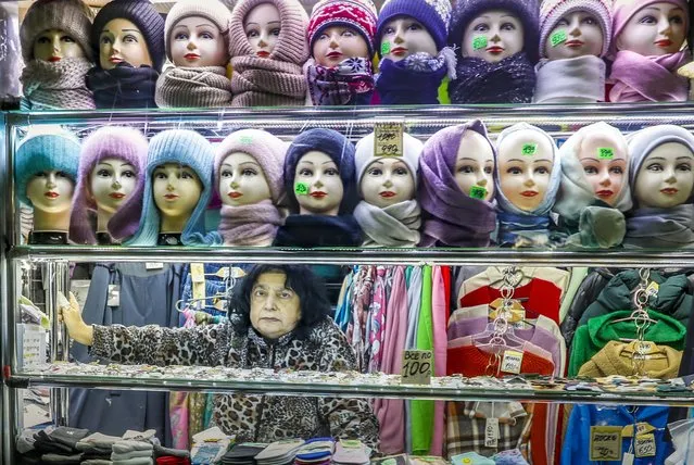 A woman sells hats, scarves and other clothes at a pavilion in an underpass in the center of Moscow, Russia, 03 April 2023. As the result of sanctions imposed by the West on Russia, a number of international brands had announced the suspension or limitation of their businesses in Russia. (Photo by Yuri Kochetkov/EPA/EFE)