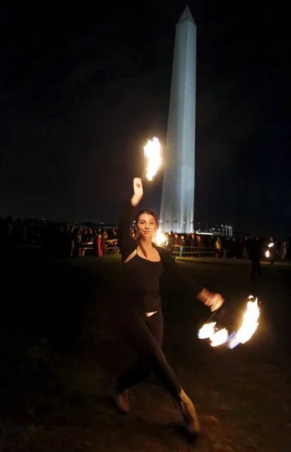 A fire performer spins a pair of "fire fans" in front of the Washington Monument during a 48-hour vigil called "Catharsis on the Mall: A Vigil for Healing the Drug War" on the U.S. National Mall in Washington November 22, 2015. (Photo by Jim Bourg/Reuters)