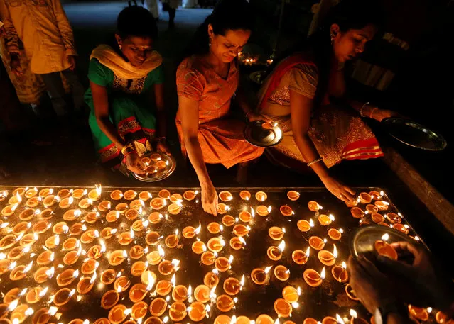 Tamil devotees lights oil lamps at a religious ceremony during the Diwali or Deepavali festival at Ponnambalavaneshwaram Hindu temple in Colombo, Sri Lanka October 29, 2016. (Photo by Dinuka Liyanawatte/Reuters)