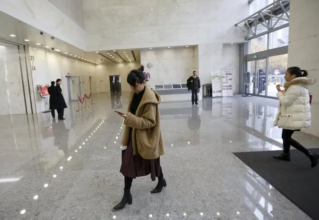 Yoko Wu uses her mobile phone as she heads to her office in Beijing, China, November 18, 2015. Yoko lives in the Beijing suburbs with her family and children. Uber, the taxi service, has become her main way to beat traffic and get work done on the road. (Photo by Kim Kyung-Hoon/Reuters)