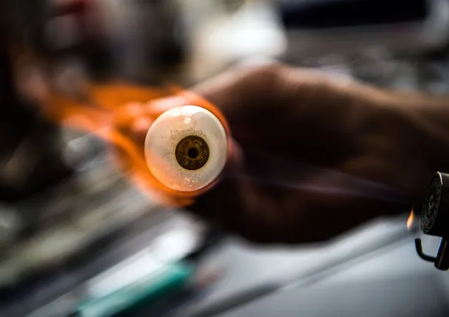 Jan Mueller- Uri, manager and ocularist, working on a glass eye with a flame in Wiesbaden, Germany on May 2, 2018. The company F. Ad. Mueller Soehne OHG produces artificial glass eyes since 1860. (Photo by Andreas Arnold/DPA)