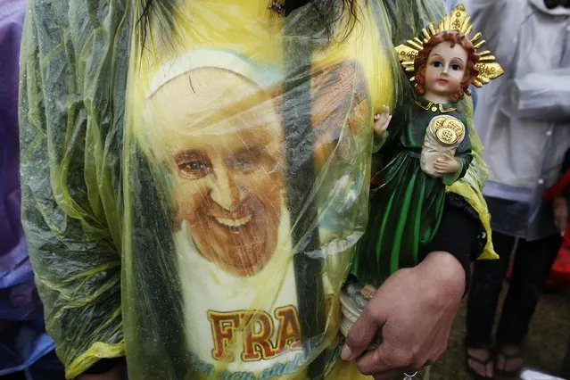A Catholic faithful holds a statue of child Jesus during an open-air Mass led by Pope Francis at Rizal Park in Manila January 18, 2015. (Photo by Cheryl Ravelo/Reuters)