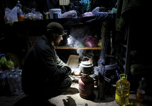 A serviceman of the 148th Separate Artillery Zhytomyr Brigade of the Armed Forces of Ukraine prepares tea in a dugout at a position on the front line, amid Russia's attack on Ukraine, near the frontline town of Pokrovsk in Donetsk region, Ukraine November 23, 2025. (Photo by Anatolii Stepanov/Reuters)