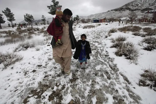 A man and his daughters walk along the snow-covered Hanna Lake after a snowfall on the outskirts of Quetta January 21, 2015. (Photo by Naseer Ahmed/Reuters)