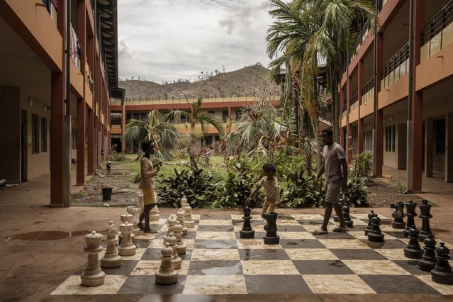 People interact by an outdoor chess board, after finding refuge at the Lycée des Lumières after losing their homes, in Mamoudzou, Mayotte, Thursday, December 19, 2024. (Photo by Adrienne Surprenant/AP Photo)