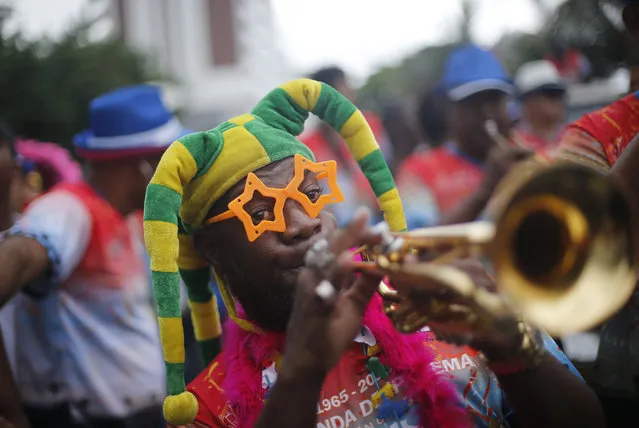 A musician plays a trumpet during the Banda de Ipanema carnival parade in Rio de Janeiro, Brazil, Saturday, January 31, 2015. (Photo by Silvia Izquierdo/AP Photo)