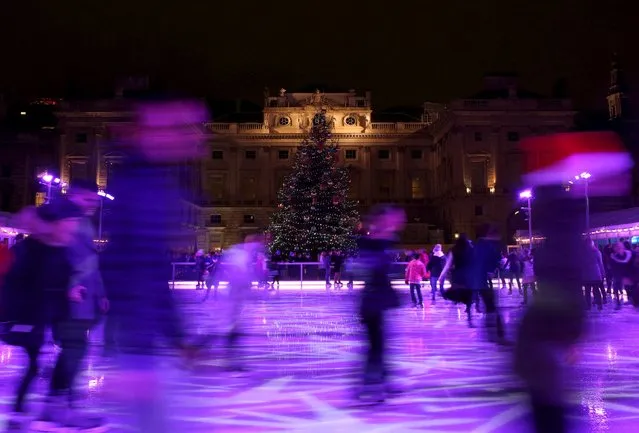 People skate past a Christmas tree on an ice-rink at Somerset House in London, Britain, December 12, 2015. The humble Christmas tree has a rich history, from evergreen trees used to symbolise eternal life in Ancient Egypt to tree worship among pagan Europeans. The modern version has its origins in Germany, where the song “O Tannenbaum” is still a festive favourite. (Photo by Neil Hall/Reuters)