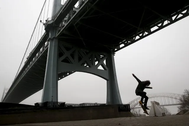 A skateboarder is seen in silhouette under a fog covered Triborough Bridge in the Queens borough of New York, December 23, 2015. (Photo by Shannon Stapleton/Reuters)