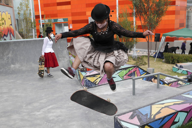 Aide Choque, wearing a mask amid the COVID-19 pandemic, jumps with her skateboard during a youth talent show in La Paz, Bolivia, Wednesday, September 30, 2020. Young women called “Skates Imillas”, using the Aymara word for girl Imilla, use traditional Indigenous clothing as a statement of pride of their Indigenous culture while playing riding their skateboards. (Photo by Juan Karita/AP Photo)
