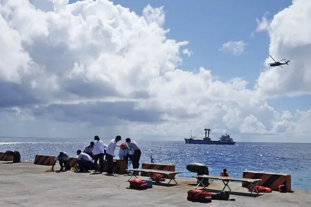 Taiwanese Coast Guard tend to a mock victim during a search-and-rescue exercise on Taiping island in the South China Sea, Tuesday, November 29, 2016, as part of Taiwan's efforts to cement its claim to a key island in the strategically vital waterbody. Eight vessels and three aircraft took part in Tuesday's drill, which simulated a fire aboard a cargo ship that forced crew members to seek safety on Taiping in the Spratly island group. (Photo by Johnson Lai/AP Photo)