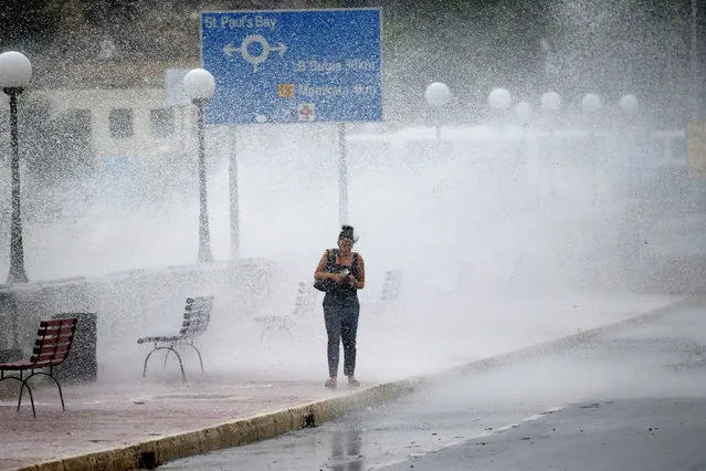 A woman gets caught in a cloud of sea spray and water as strong winds and rough seas batter the coast of the Maltese islands, in St Paul's Bay, Malta September 26, 2018. (Photo by Darrin Zammit Lupi/Reuters)