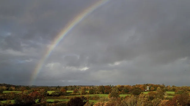A rainbow appears over an oast house, near Hawkhurst in Kent, England, Tuesday, November 3, 2020. Oast houses are a distinctive feature of the Kent and Sussex landscape and were constructed originally to dry the harvested mature hops used as an ingredient in brewing beer. (Photo by Gareth Fuller/PA Wire via AP Photo)