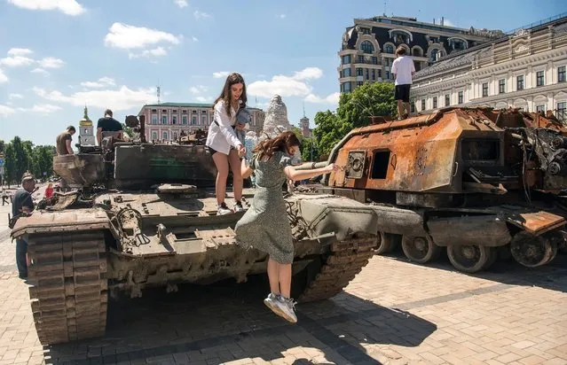 People look at destroyed Russian armored vehicles displayed for Ukrainians to see at Mykhailivska Square in downtown Kyiv, Ukraine, June 03, 2022 (Photo by Maxym Marusenko/NurPhoto via Getty Images)