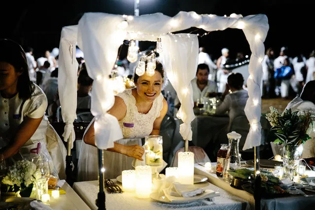 People take part in the Diner en Blanc at Governors Island in New York, New York, USA, 17 September 2018. The international gathering is attended by people dressed in white who share a gourmet dinner with friends. (Photo by Alba Vigaray/EPA/EFE)