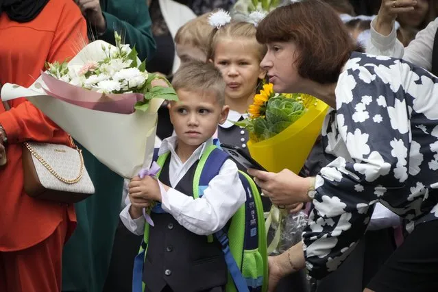 First graders enter a school yard to take part in a ceremony marking the start of classes at a school as part of the traditional opening of the school year known as “Day of Knowledge” in St. Petersburg, Russia, Friday, September 1, 2023. Many schools across the country reopen on Sept. 1. (Photo by Dmitri Lovetsky/AP Photo)