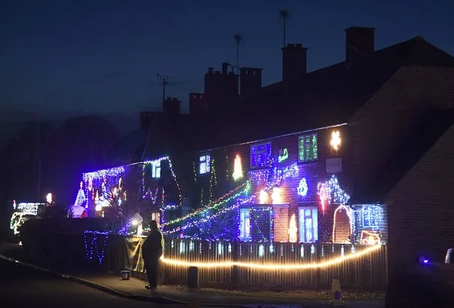 Visitors and locals view Christmas displays on dozens of properties that have been decorated in thousands of lights in a tradition that has grown over recent years in the small village of Westfield in Sussex, south east England, December 15, 2016. (Photo by Toby Melville/Reuters)