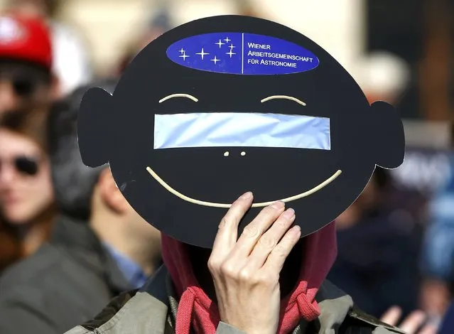 A woman uses a solar viewing filter to observe a partial solar eclipse in Vienna March 20, 2015. (Photo by Leonhard Foeger/Reuters)