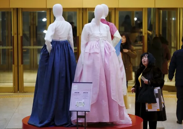 A Chinese tourist looks at Korean traditional dress Hanbok on display at a Lotte department store in central Seoul, South Korea, February 2, 2016. (Photo by Kim Hong-Ji/Reuters)