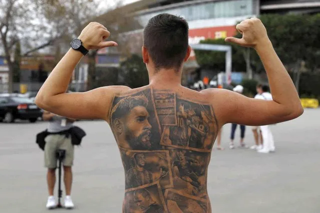 A Barcelona fan poses showing tattoos of Lionel Messi and other Barcelona players before FC Barcelona club President Joan Laporta gives a news conference in Barcelona, Spain, Friday, August 6, 2021. Barcelona announced on Thursday Aug. 5, 2021 that Messi will not stay with the club. He is leaving after 17 successful seasons in which he propelled the Catalan club to glory, helping it win numerous domestic and international titles since debuting as a teenager. (Photo by Joan Monfort/AP Photo)