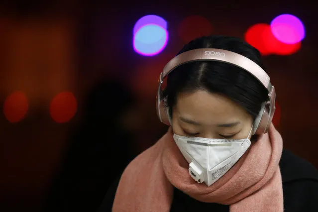 A woman wears a face mask as she walks on a street on a polluted day in Beijing, China, January 4, 2017. (Photo by Thomas Peter/Reuters)