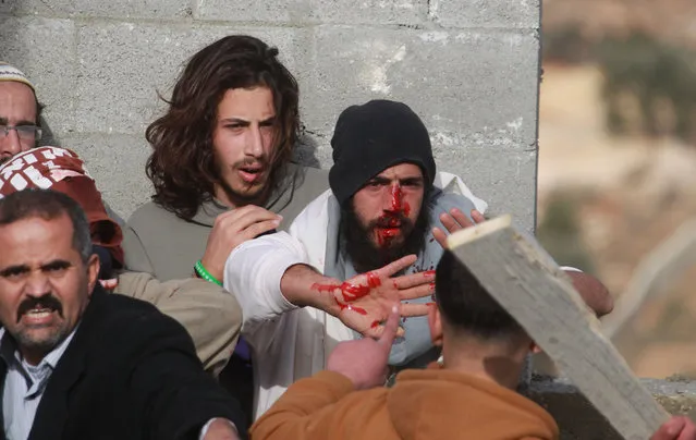 Injured Israeli settlers appeal to Palestinians not to hit them while they are detained by Palestinian villagers in a building under construction near the West Bank village of Qusra, southeast of the city of Nablus, Tuesday, January 7, 2014. (Photo by Nasser Ishtayeh/AP Photo)