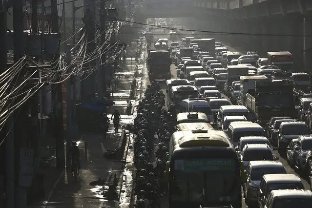 Traffic builds up near a checkpoint during a stricter lockdown as a precaution against the spread of the new coronavirus disease at the outskirts of Marikina City, Philippines on Friday, August 6, 2021. (Photo by Basilio Sepe/AP Photo)