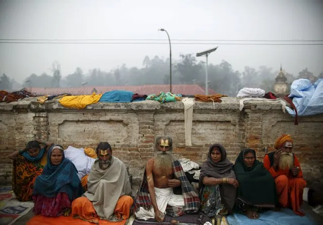 Hindu holy men, or sadhus, along with devotees sit at the premises of Pashupatinath Temple in Kathmandu, Nepal March 6, 2016. (Photo by Navesh Chitrakar/Reuters)