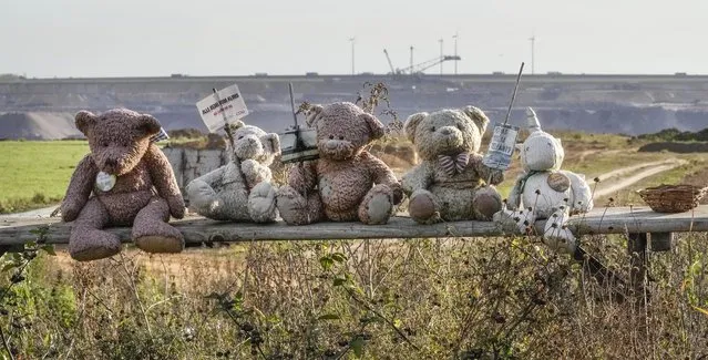 Climate activists protest against the Garzweiler open-cast coal mine with Teddy bears in Luetzerath, western Germany, Friday, October 1, 2021. The village of Luetzerath, now almost entirely abandoned as the mine draws ever closer, will be the latest village to disappear as coal mining at the Garzweiler mine expands. The sign left reads: “all talk about the climate – we ruin it, CDU”. CDU is Germany's Christian Democratic Union party. (Photo by Martin Meissner/AP Photo)