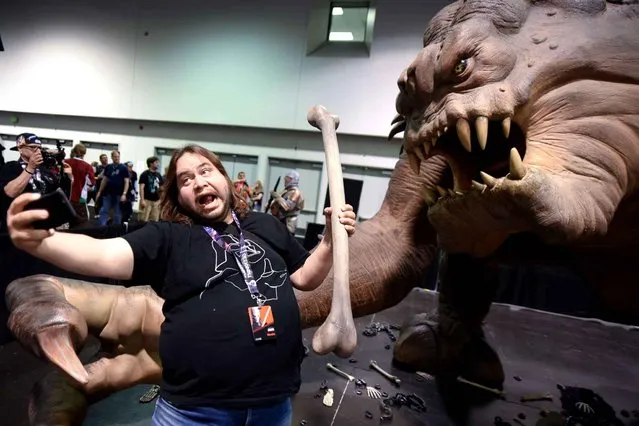 A Star Wars fan takes a selfie with the Roxy the Rancor exhibit at Star Wars Celebration: The Ultimate Fan Experience held at the Anaheim Convention Center on Thursday, April 16, 2015, in Anaheim, Calif. (Photo by Richard Shotwell/Invision/AP Photo)