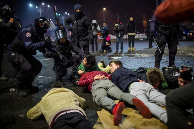 Riot police detain protesters during a protest in front of the government headquarters  against controversial decrees to pardon corrupt politicians and decriminalize other offenses in Bucharest on February 1, 2017. Over 100,000 people in Bucharest only, 200,000 allover the country rally for a second day in row after a controversial law giving pardon to corruption crimes was adopted  by emergency order late evening on Tuesday. (Photo by Andrei Pungovschi/AFP Photo)