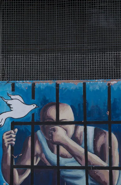This April 14, 2015 photo shows a mural of a prisoner behind bars and a flying dove on the wall inside a courtyard at the now empty Garcia Moreno Prison, during a guided tour for the public in Quito, Ecuador. Psychologist Oscar Ortiz, who worked with the inmates behind these walls, organized local artists to collaborate with the prisoners to adorn the walls with paintings. (Photo by Dolores Ochoa/AP Photo)