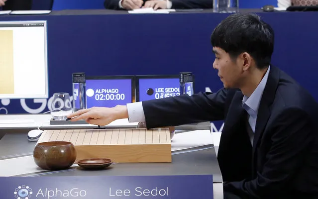 South Korean professional Go player Lee Sedol puts the first stone against Google's artificial intelligence program, AlphaGo, as Google DeepMind's lead programmer Aja Huang, left, sits during the final match of the Google DeepMind Challenge Match in Seoul, South Korea, Tuesday, March 15, 2016. A champion Go player scored his first win over a Go-playing computer program on Sunday after losing three straight times in the ancient Chinese board game, saying he finally found weaknesses in the software. (Photo by Lee Jin-man/AP Photo)