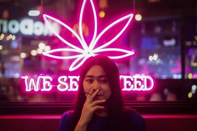 Pim smokes a joint outside the cannabis shop where she works, in Bangkok, Thailand, on August 19, 2023. (Photo by Jorge Silva/Reuters)
